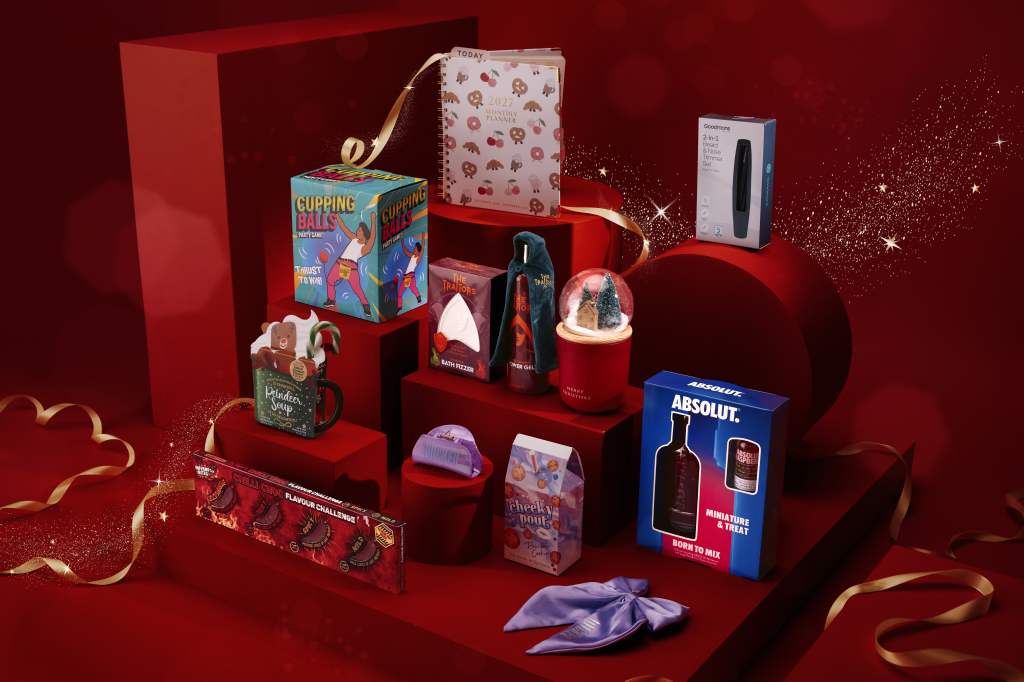 Festive gift boxes and beauty products on red display with ribbons