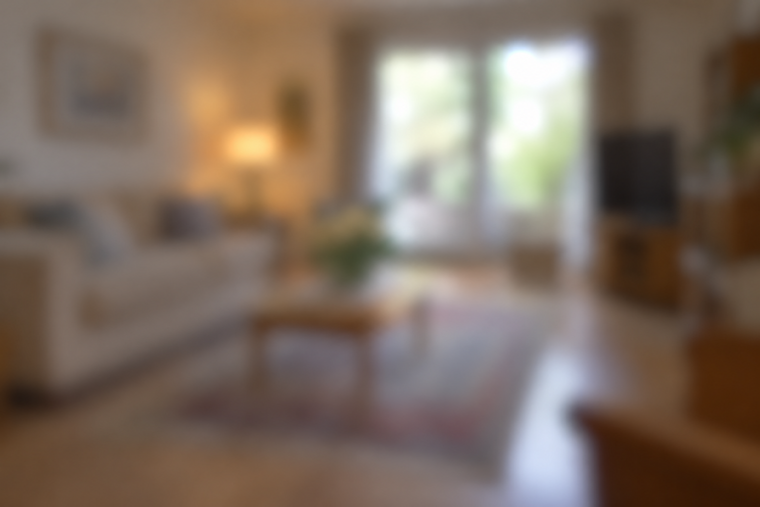 Cosy living room with beige sofa, wooden table, and large window