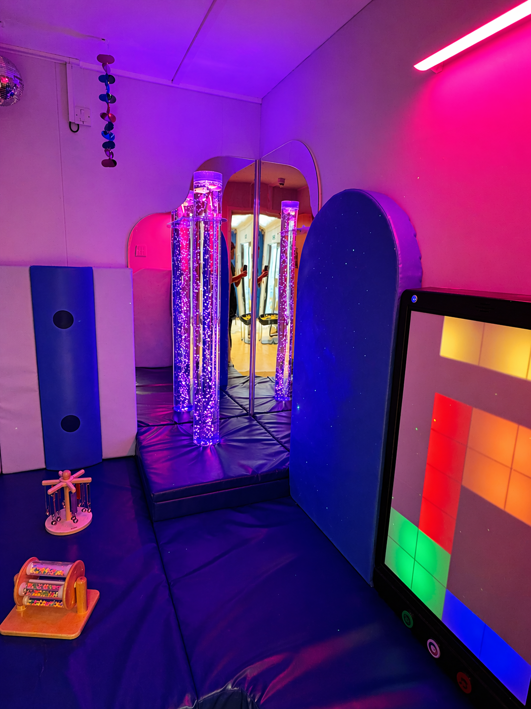 Sensory room with colorful lights and interactive panels