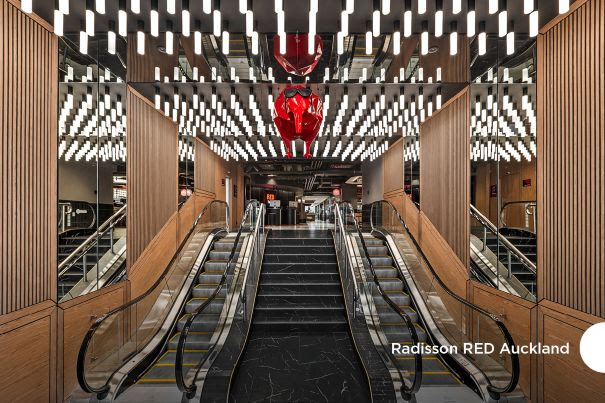Modern hotel lobby with escalators and mirrored ceiling