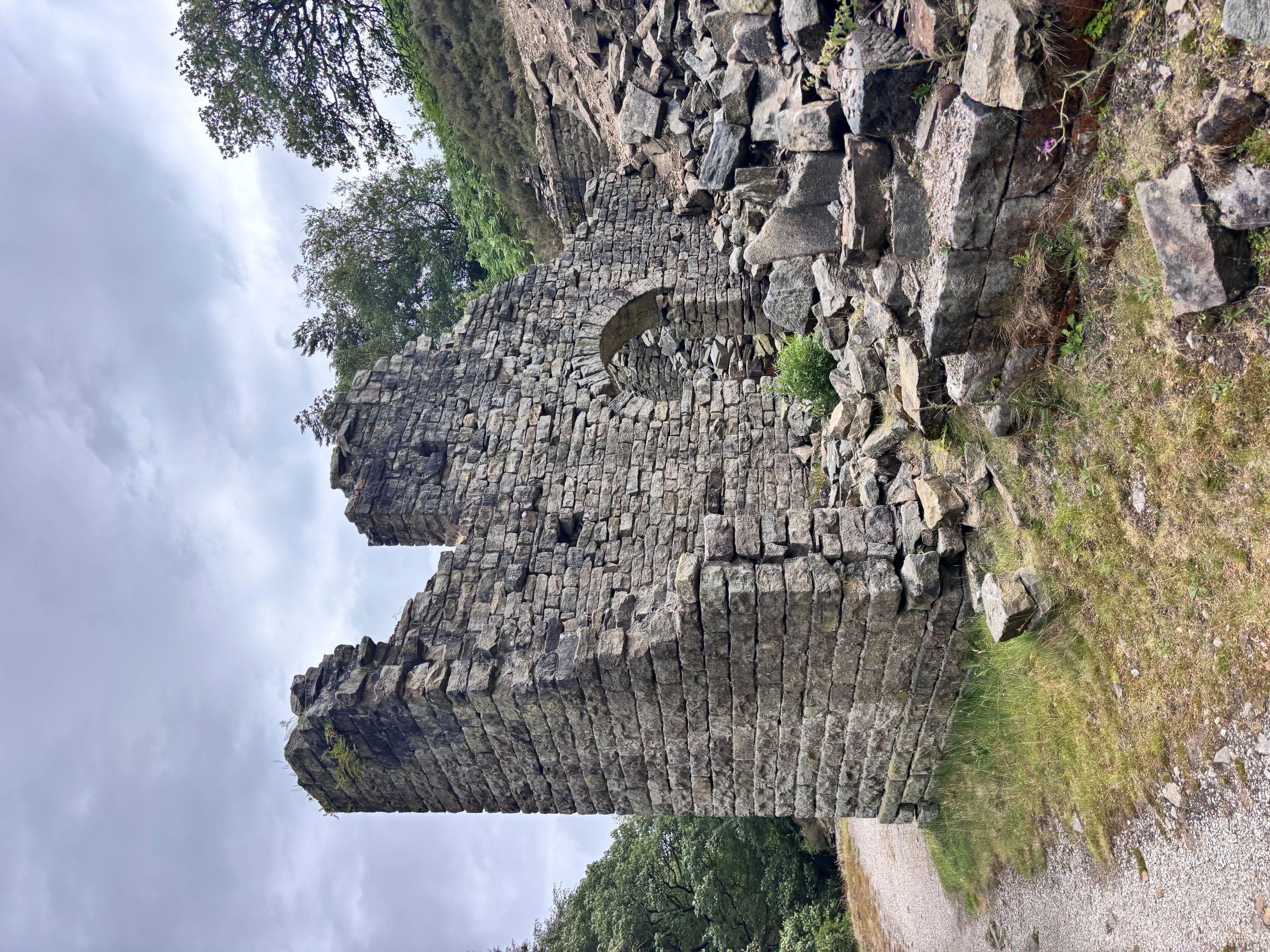 Ruined stone building with archway in lush countryside