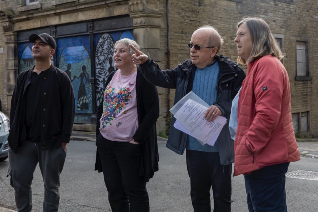 Group of people in casual clothes discussing in front of mural