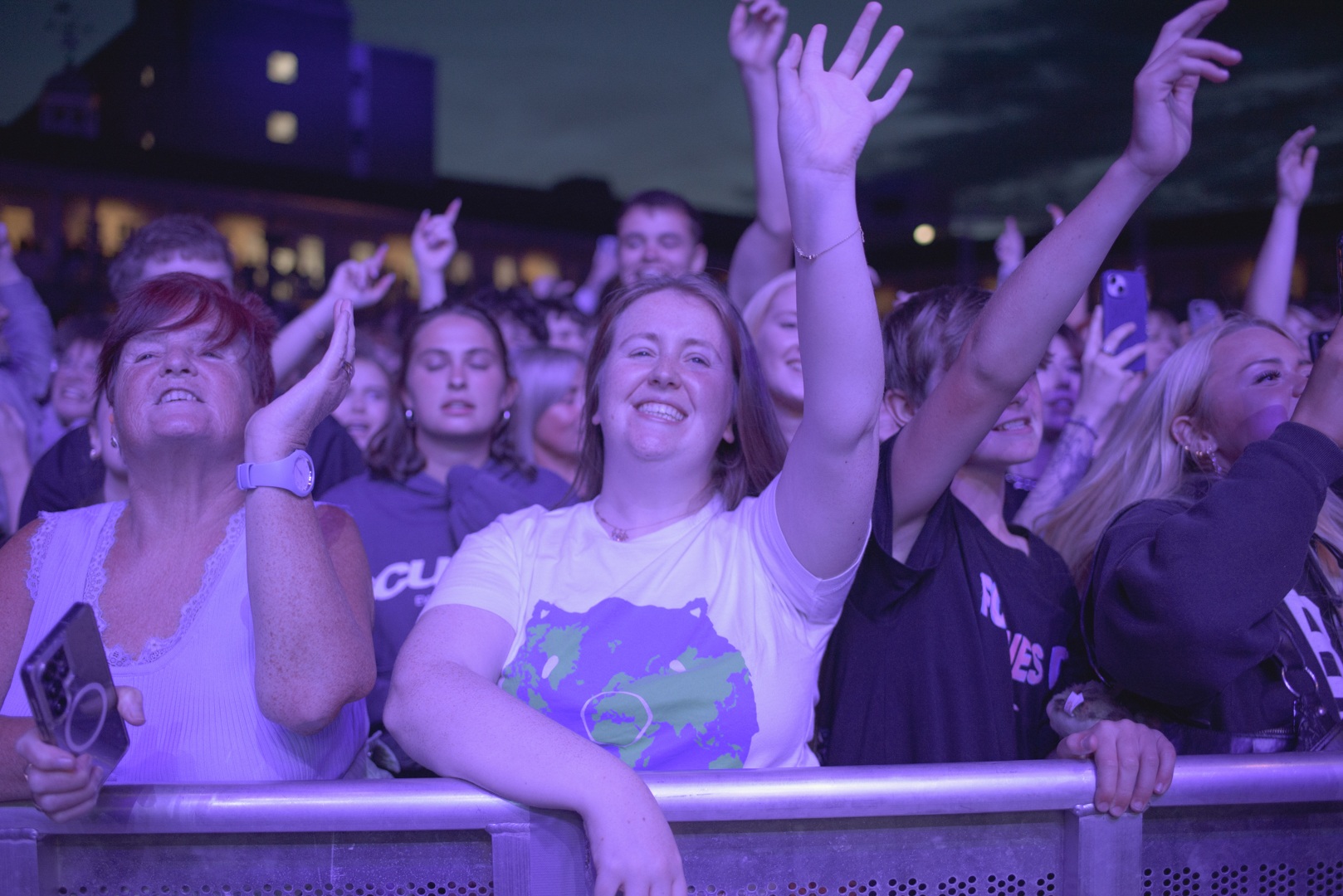 Excited crowd of young people enjoying an outdoor concert