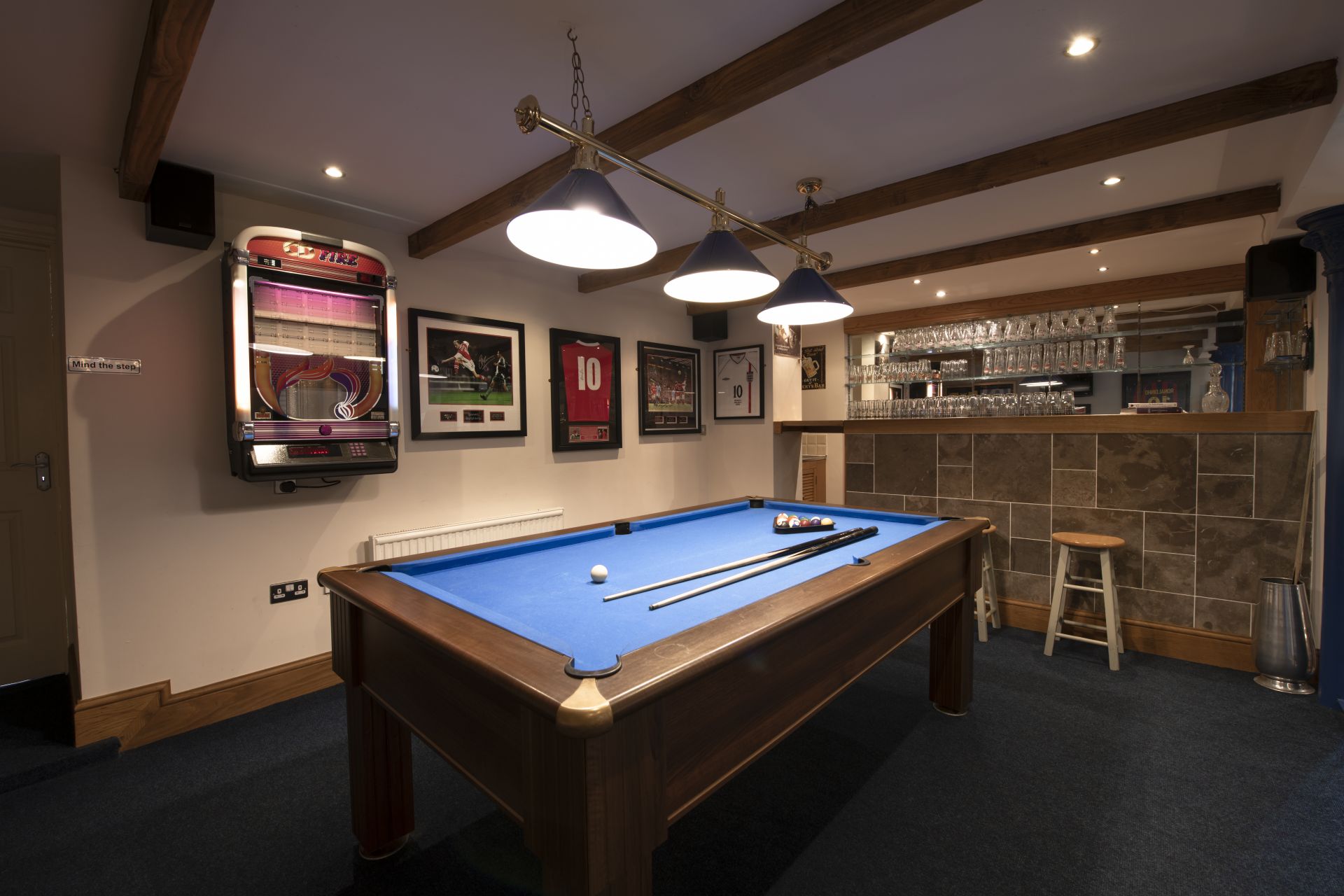 Cozy pub interior with pool table and framed sports photos