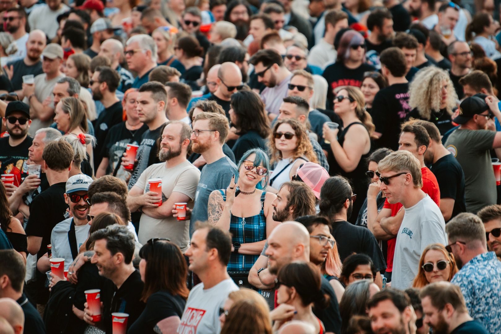 Large crowd at outdoor festival in Yorkshire, people holding drinks