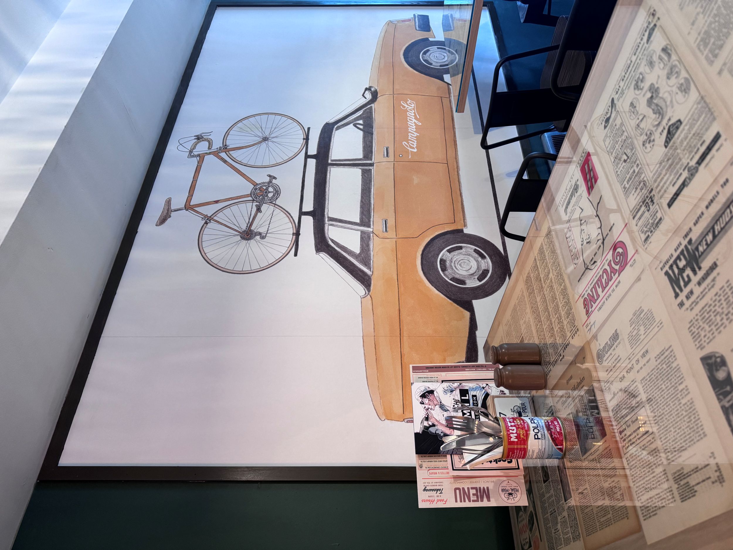 Vintage orange car with bicycle on roof mural in cafe