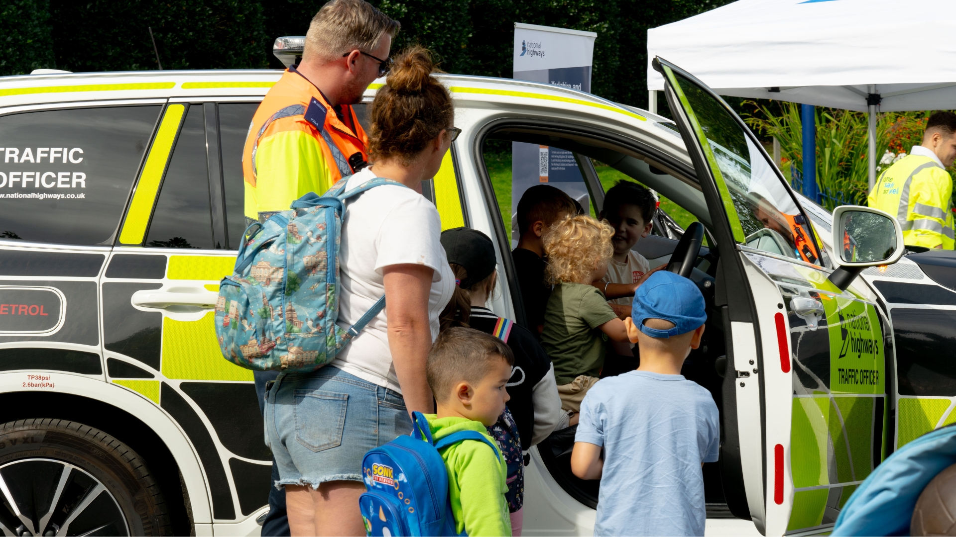 Children exploring a traffic officer vehicle at a fair
