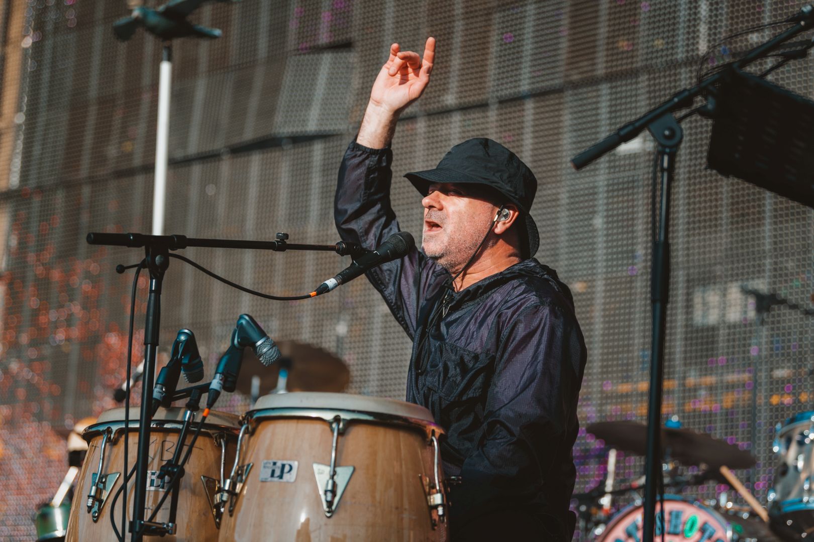 Musician playing conga drums on stage at outdoor festival