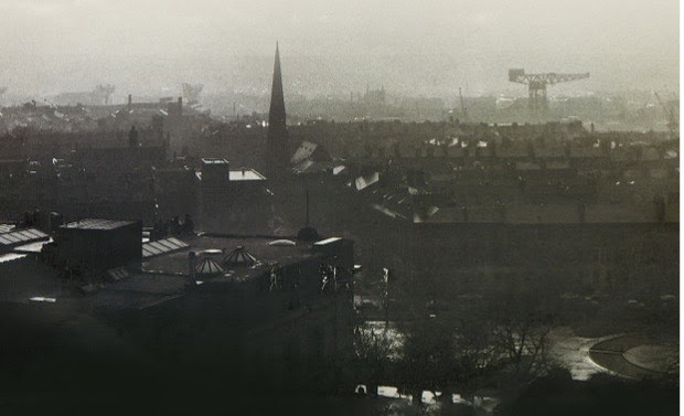 Misty skyline of industrial town with church spire and crane
