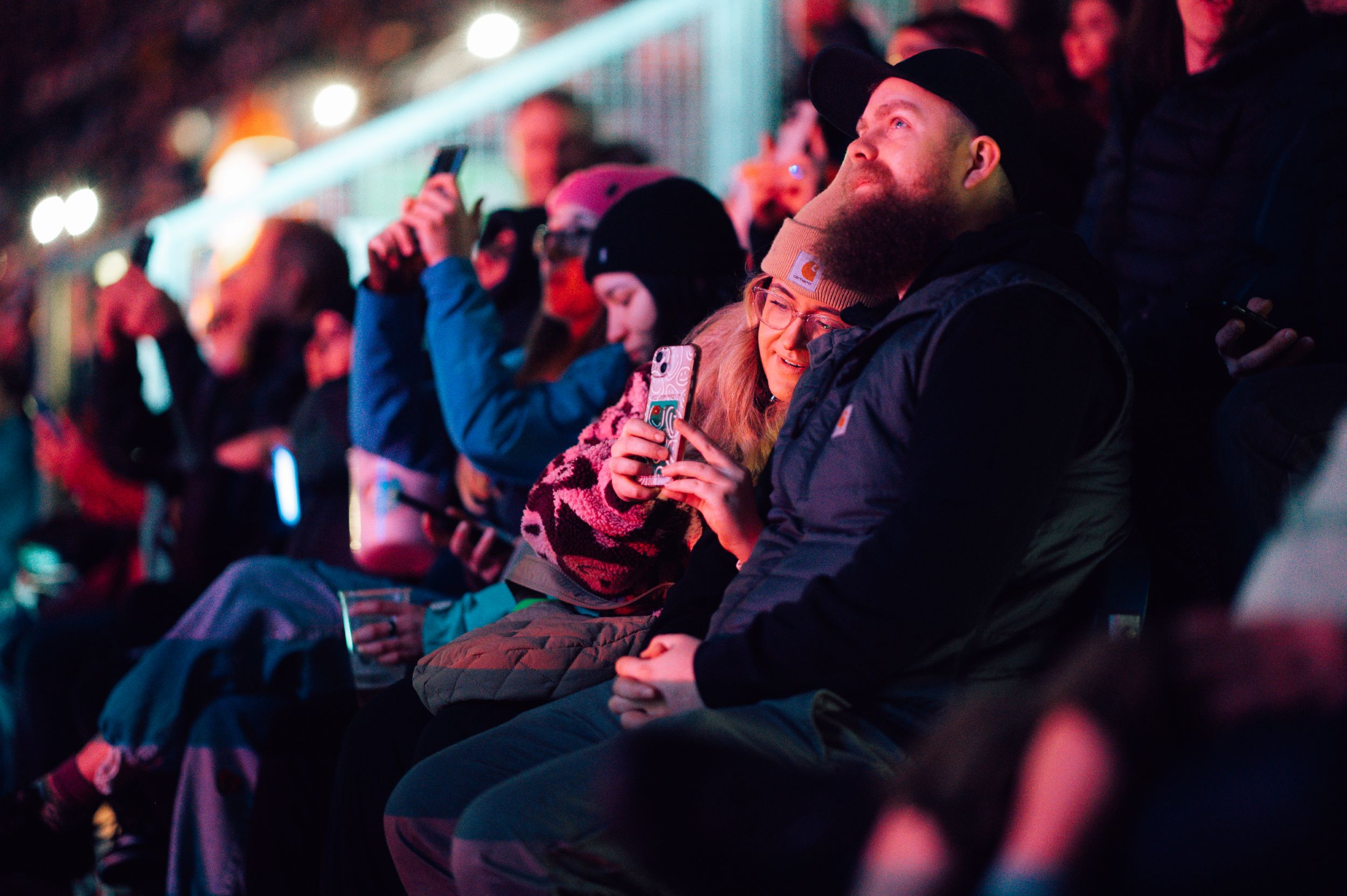 People in warm clothing enjoying night festival with lights