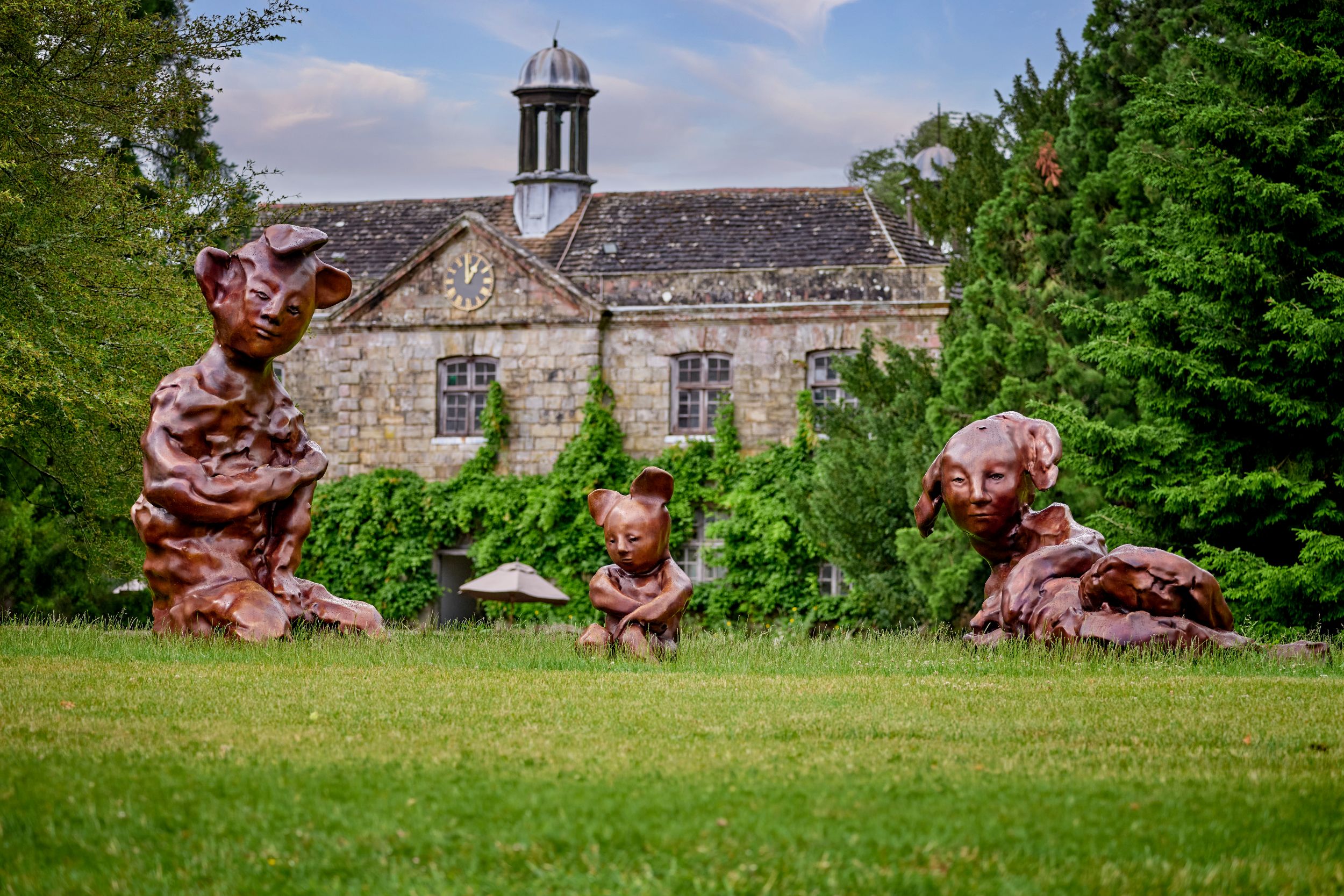 Quirky animal sculptures on lawn with historic stone building