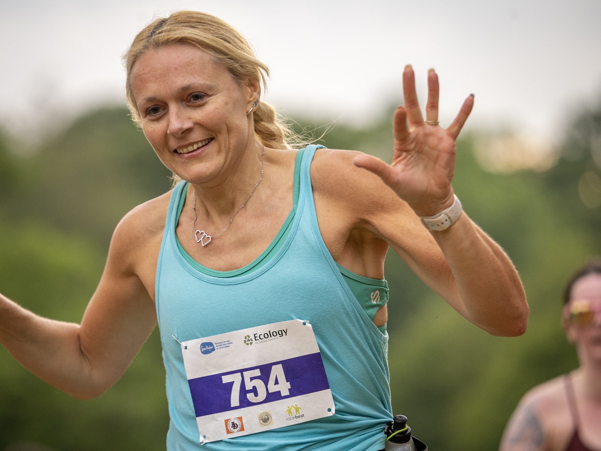 Woman in blue tank top running in Yorkshire countryside