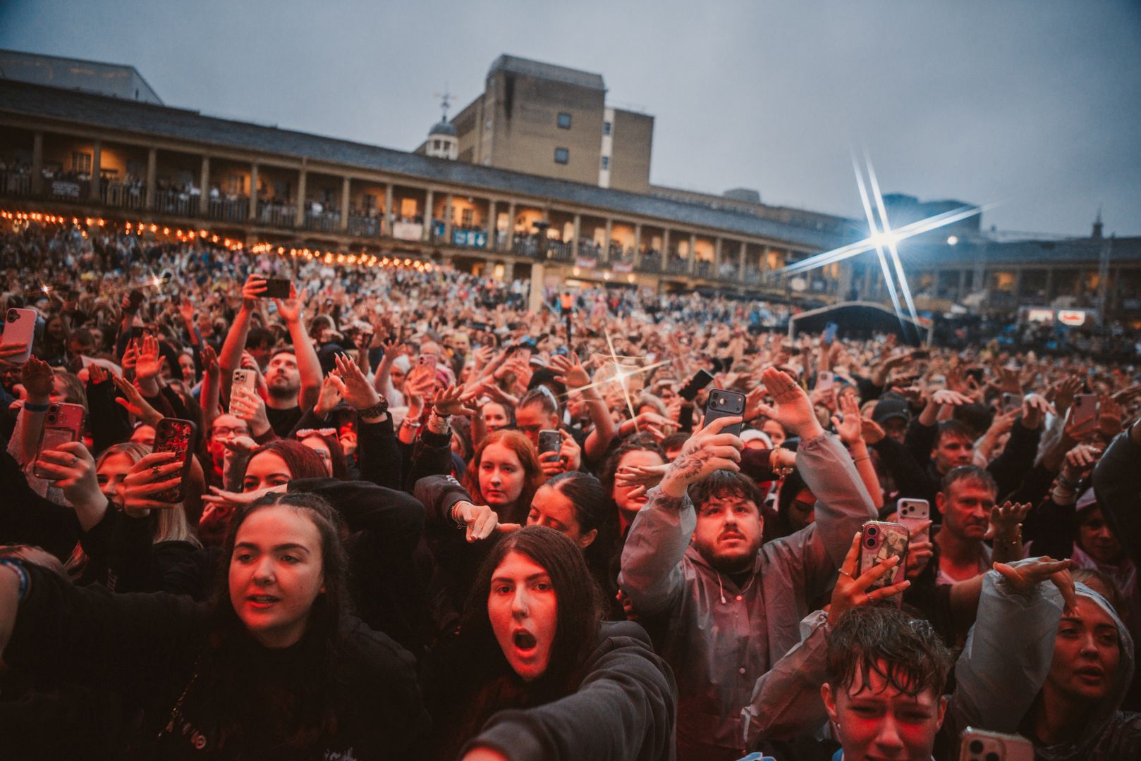 Crowd of concertgoers at night in front of historic building
