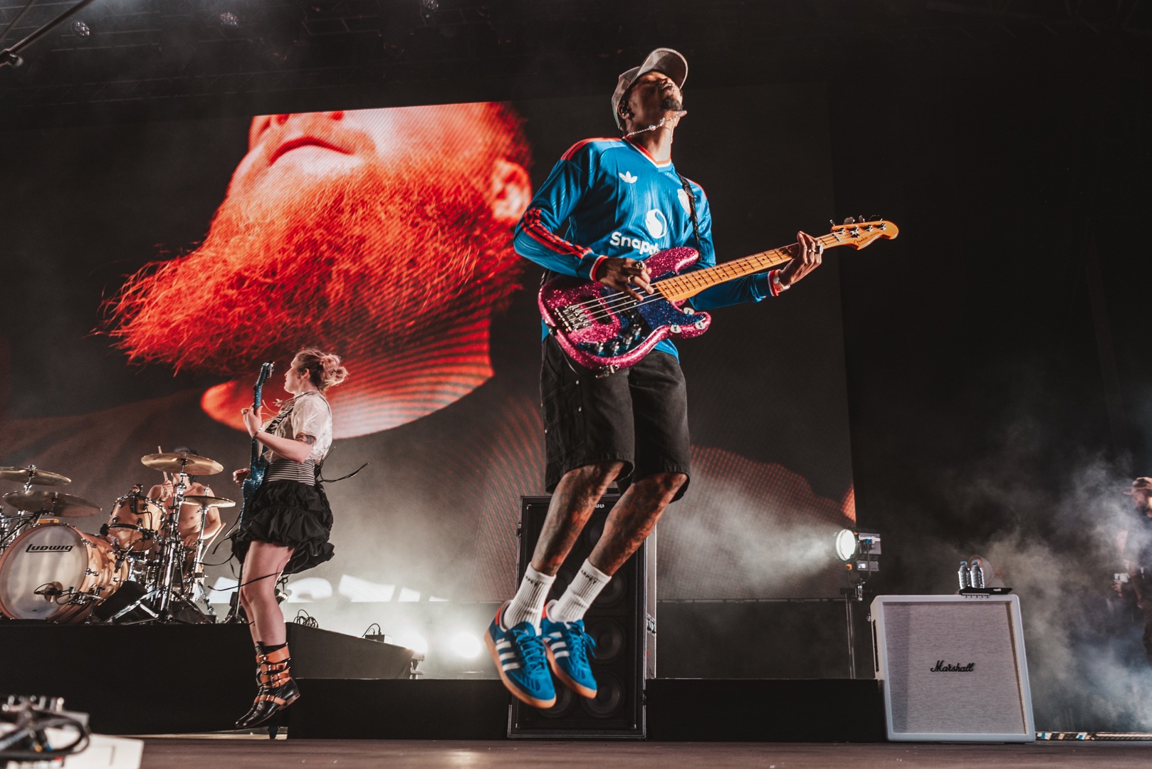 Energetic band performance with bassist jumping on stage