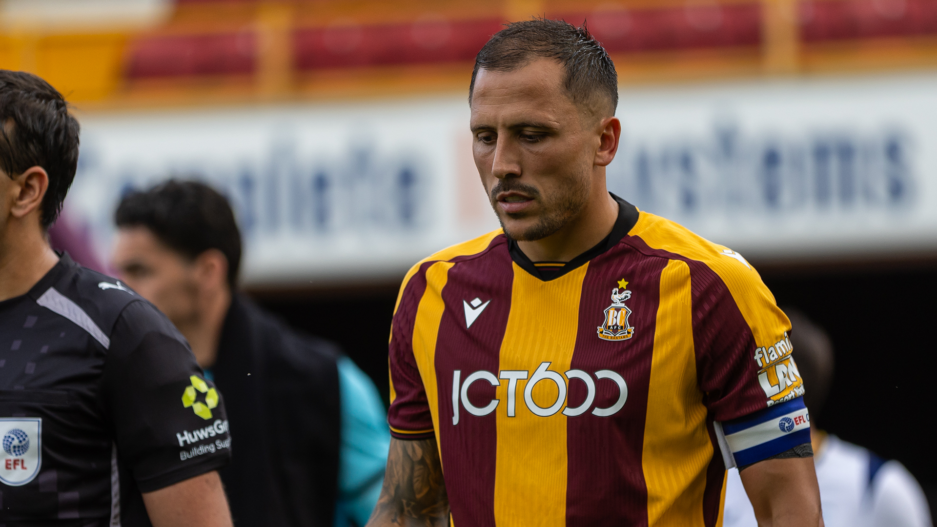 Footballer in Bradford City kit walking on pitch