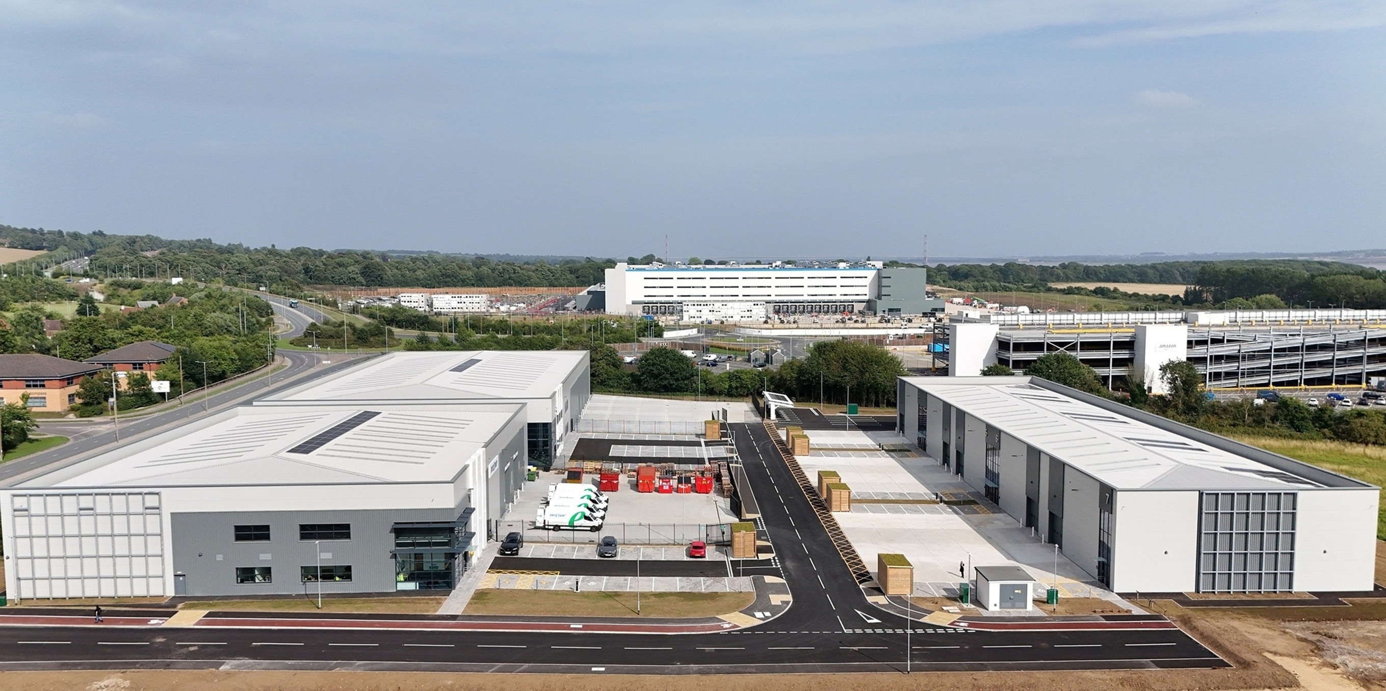 Modern industrial estate with white buildings and parking area