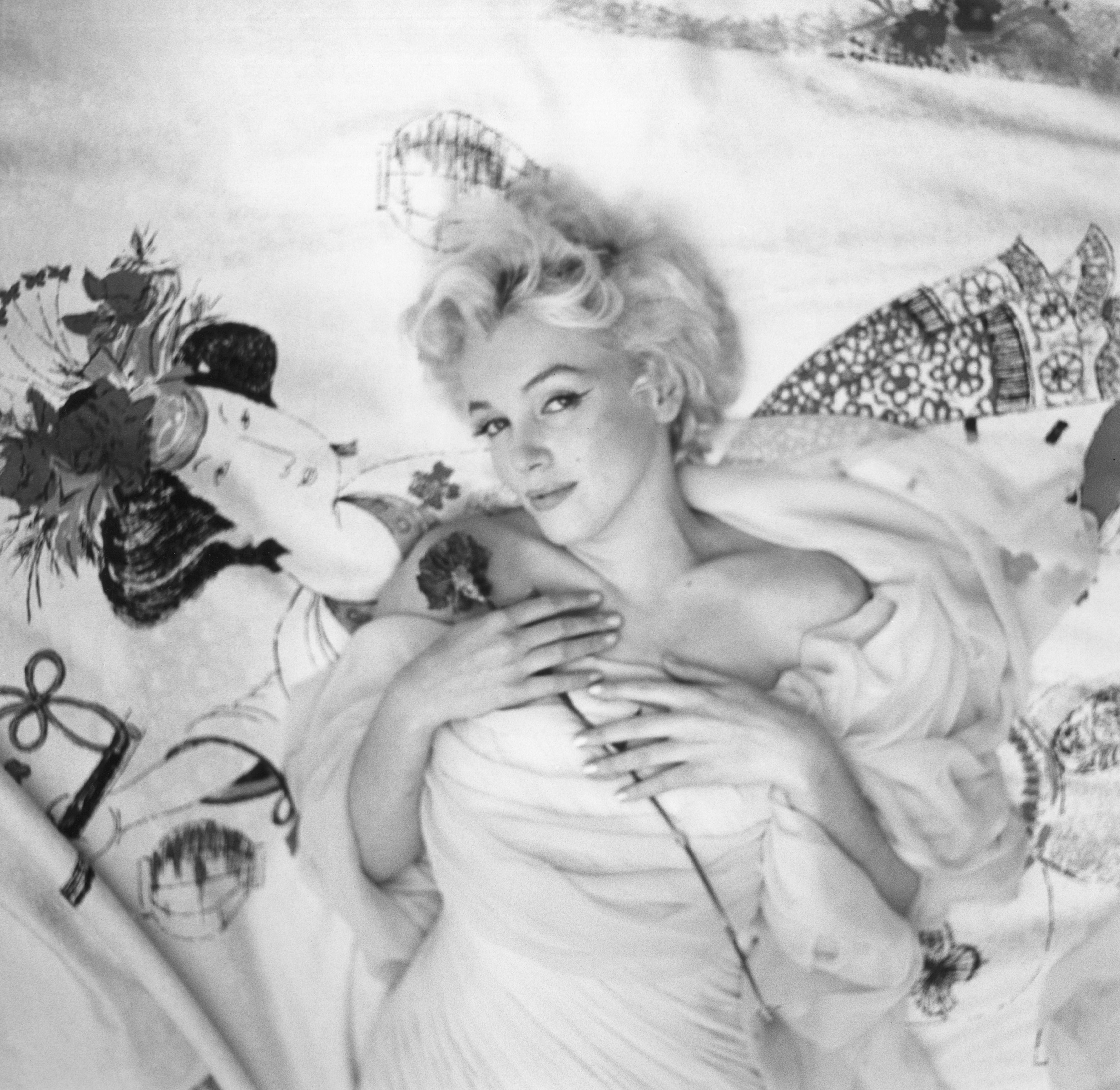 Woman in white dress reclining on Japanese-themed fabric