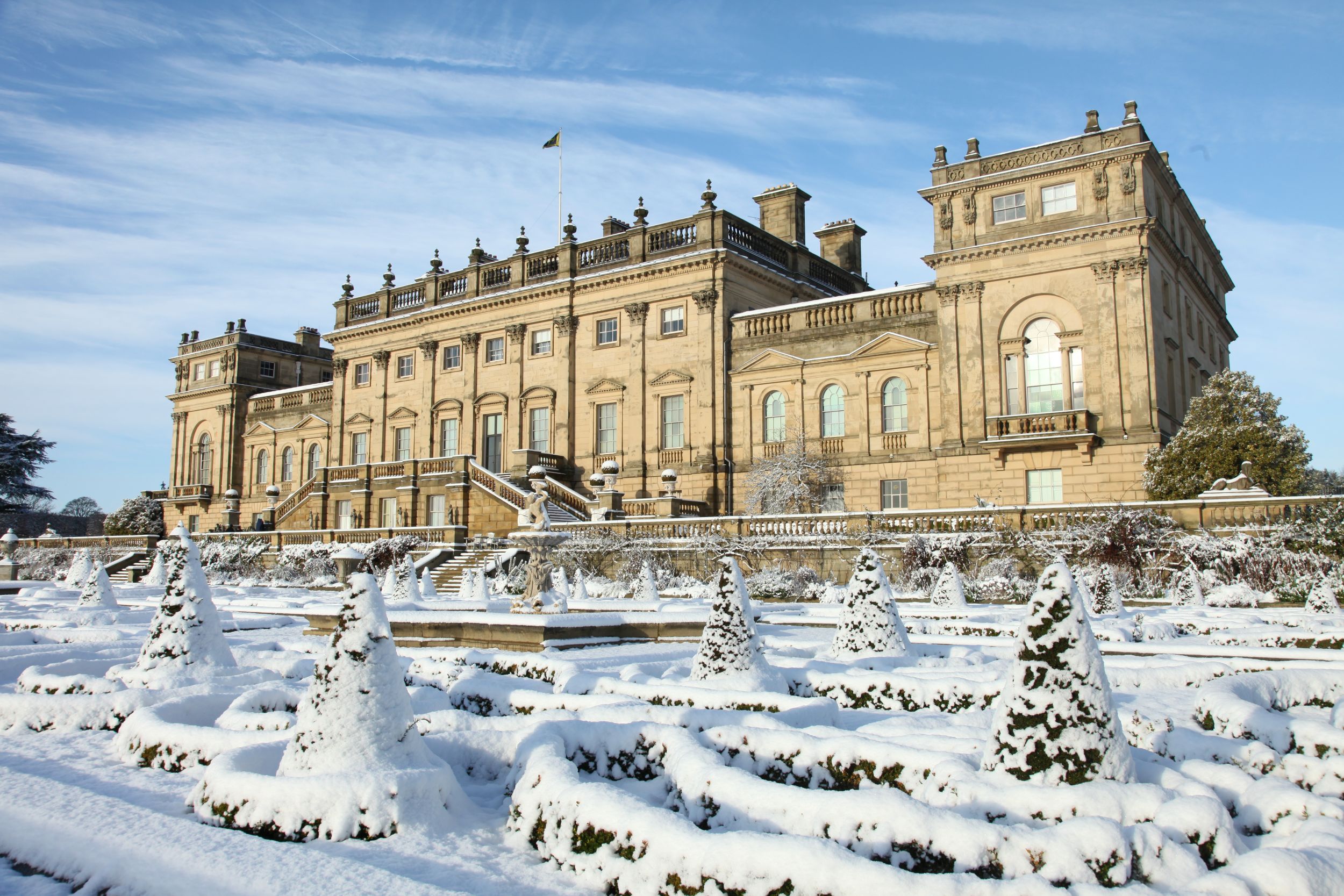 Grand historic estate house with snow-covered gardens