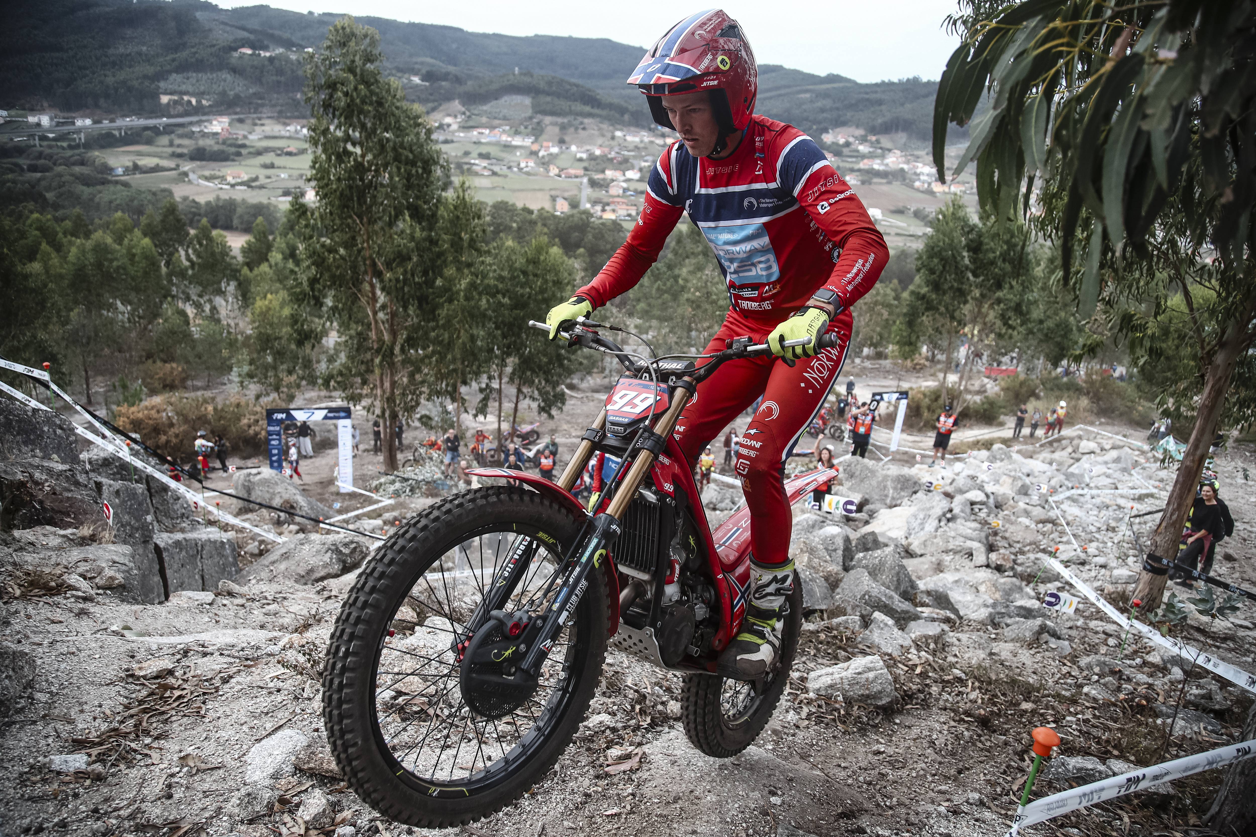 Motorcyclist navigating rocky terrain in forested hills