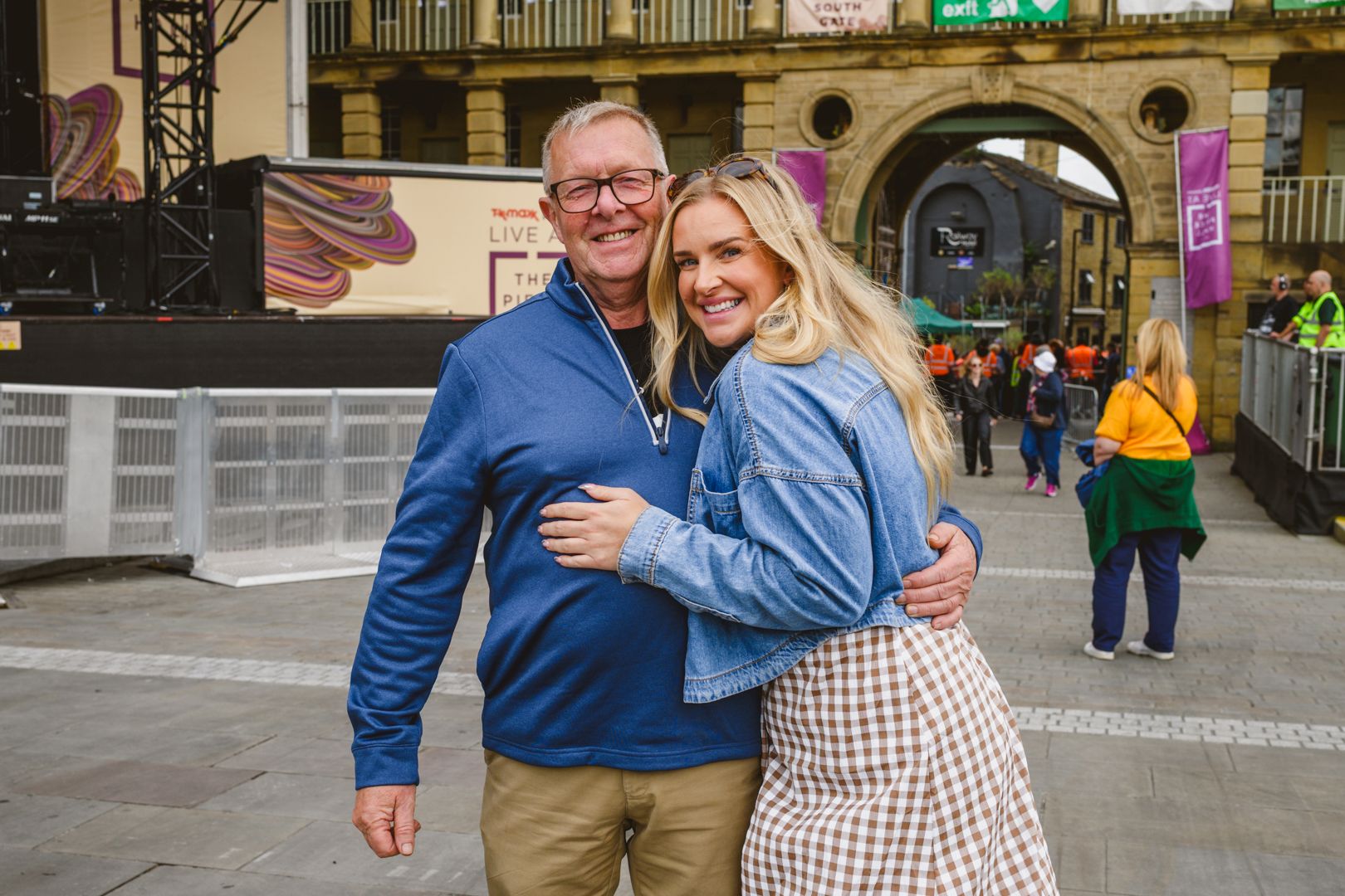 Smiling man and woman embracing in bustling town square