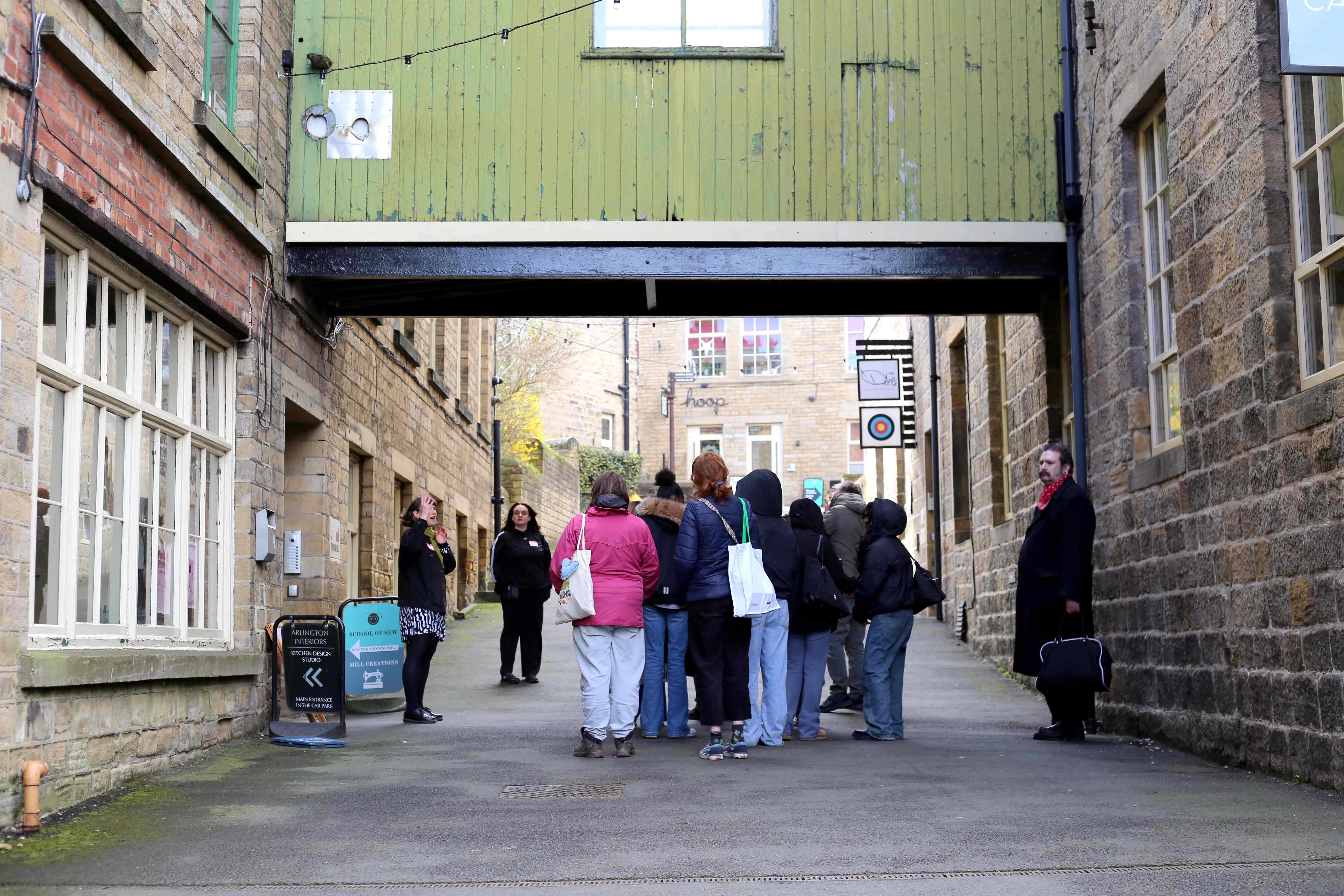 Group of tourists listening to a guide in a cobbled alleyway