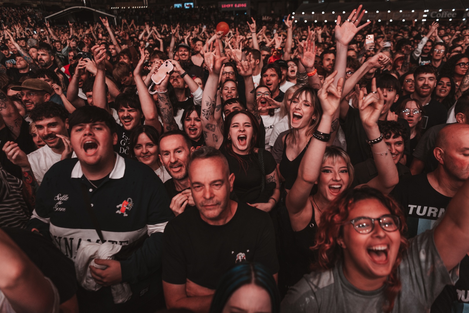 Excited crowd at a lively outdoor music festival at night