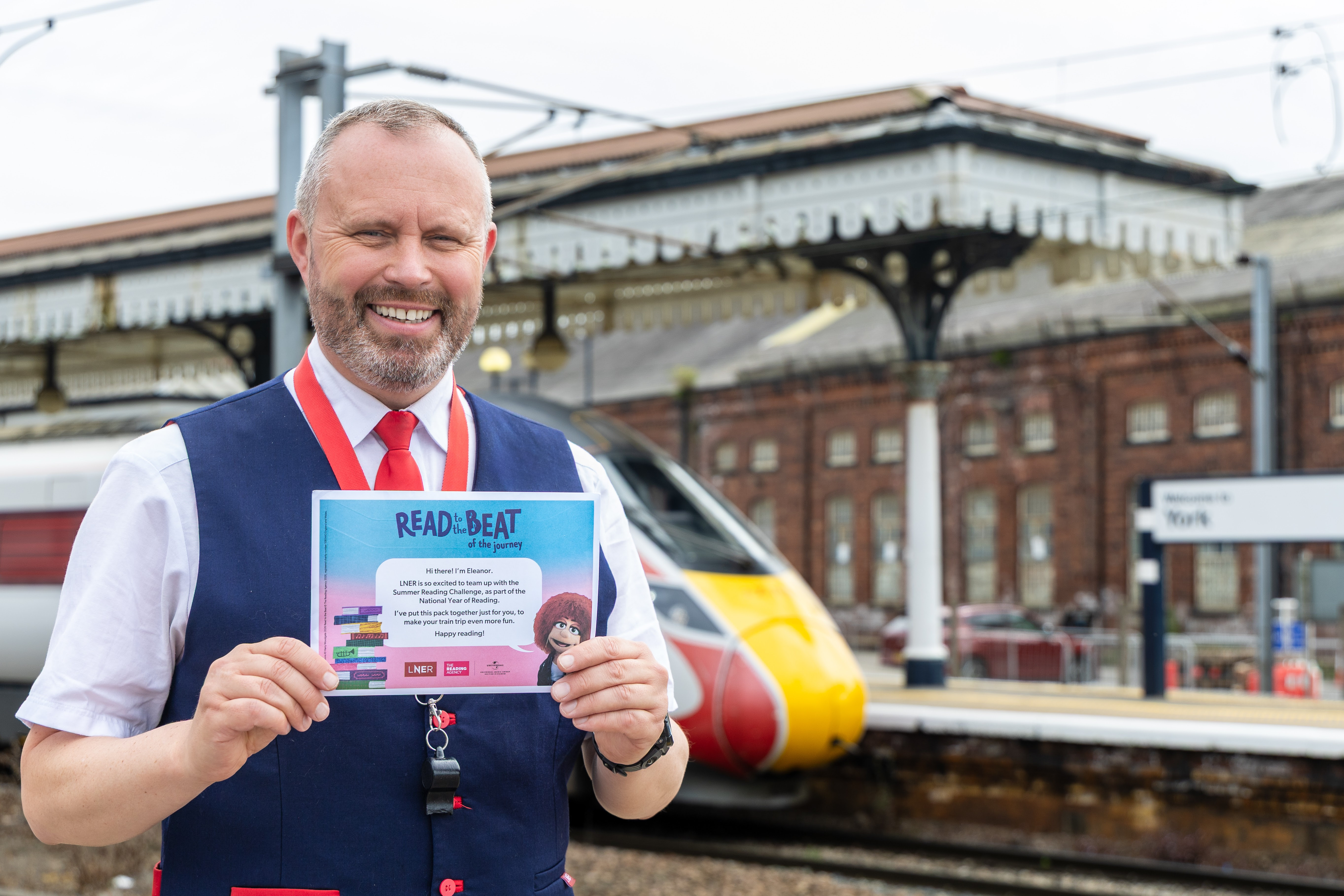 Train conductor holding certificate on York station platform