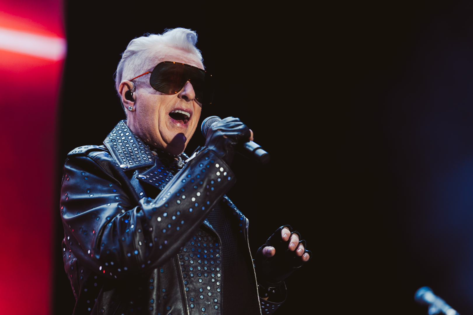 Singer in studded leather jacket and sunglasses performing
