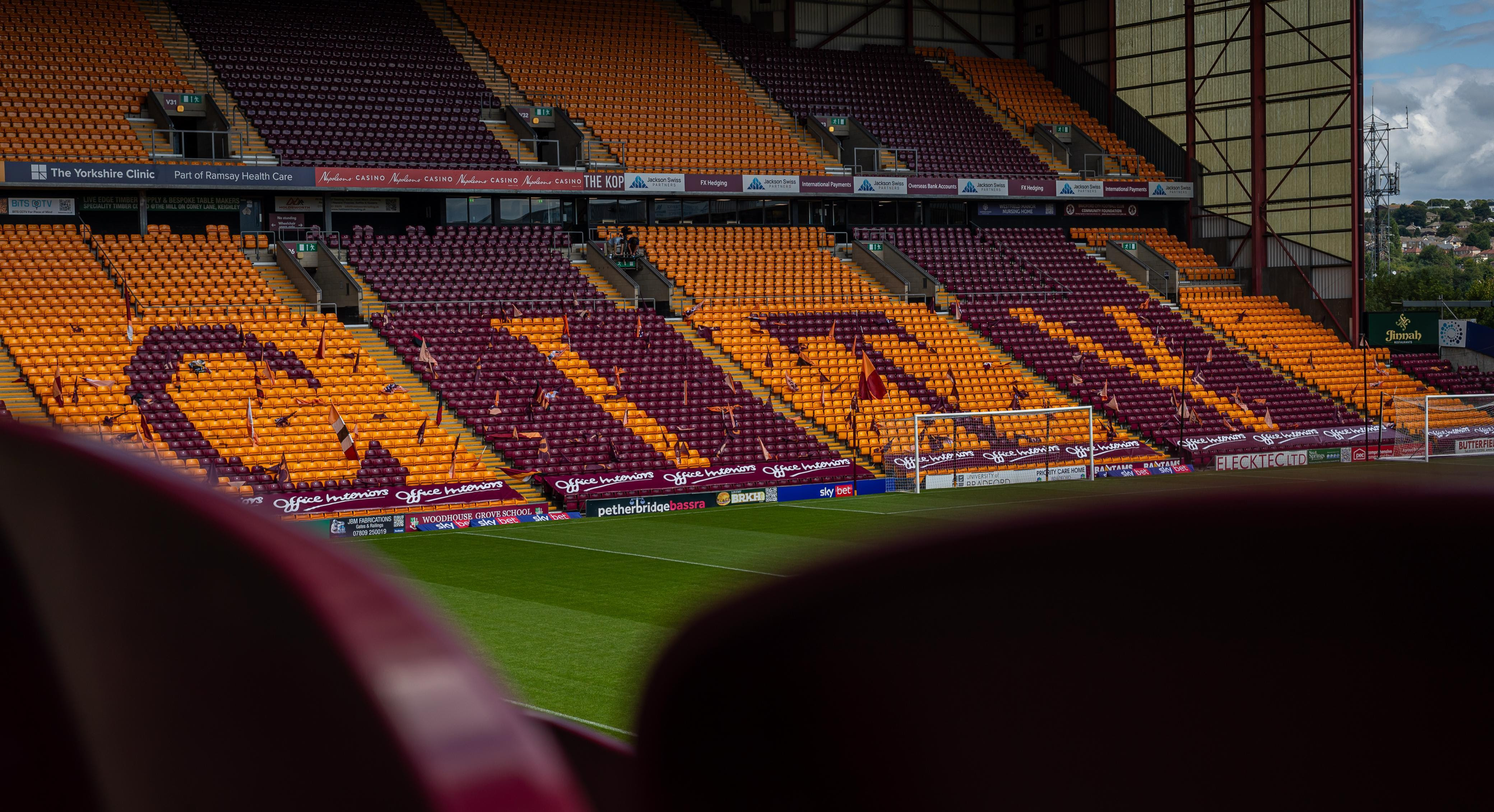 Football stadium with claret and amber seats forming word City