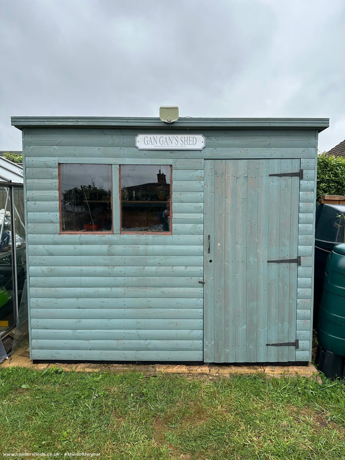 Wooden shed with blue paint and sign reading 'Gan Gan's Shed'