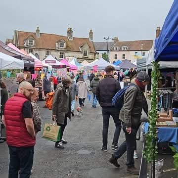 Busy outdoor market with colorful stalls and shoppers