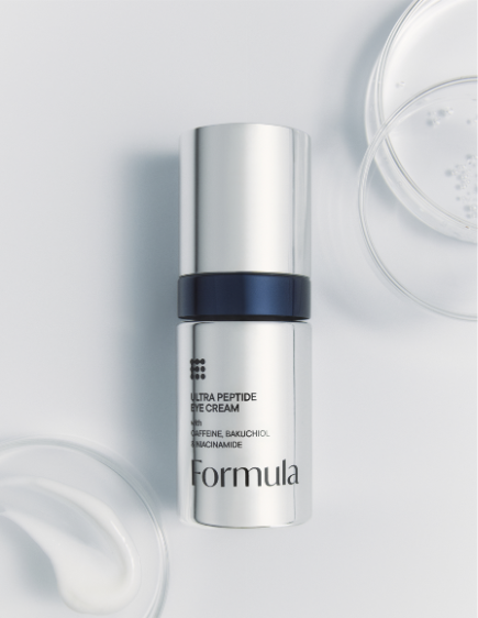 Silver skincare bottle with black accent on white surface