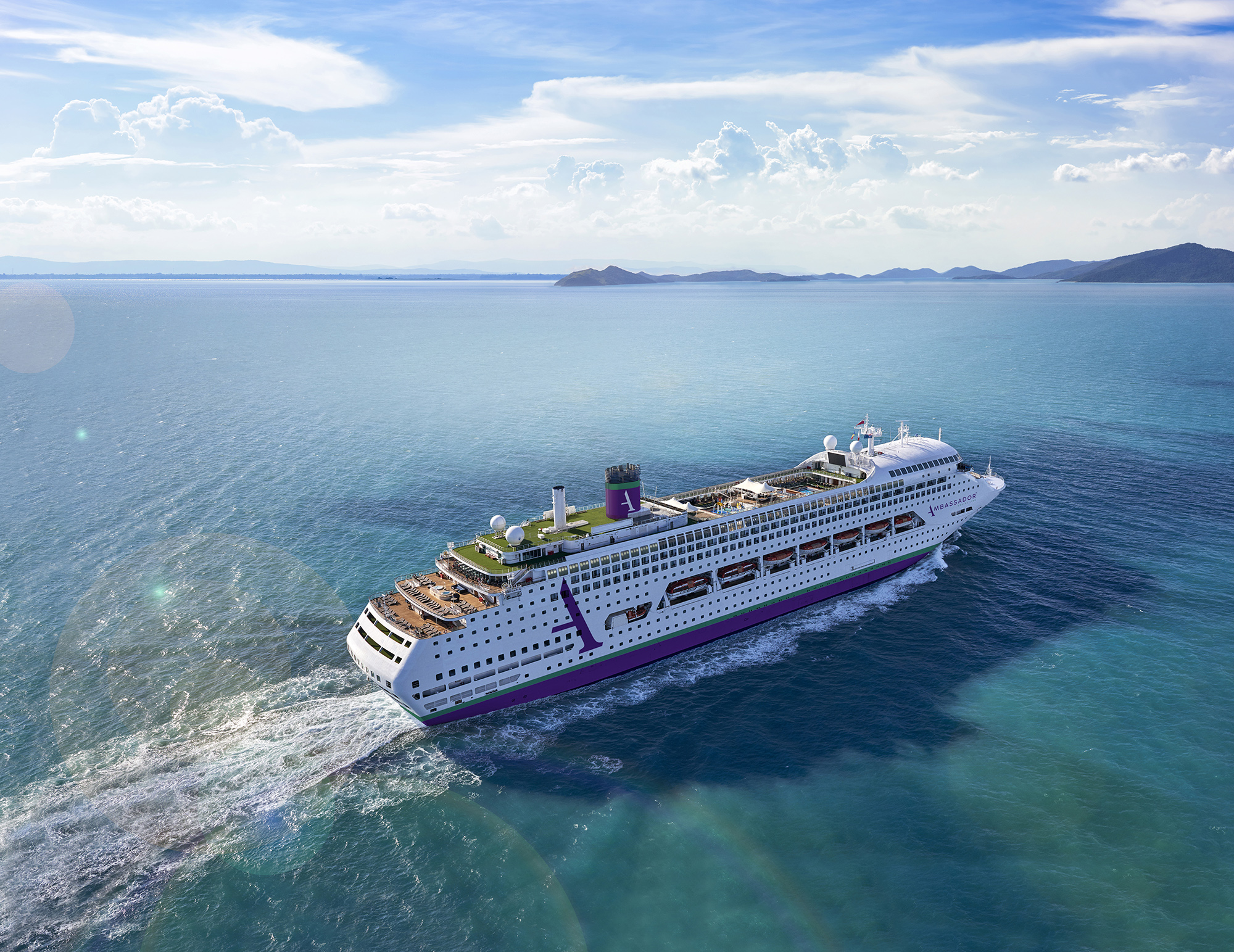 Large white cruise ship sailing on blue sea under clear sky