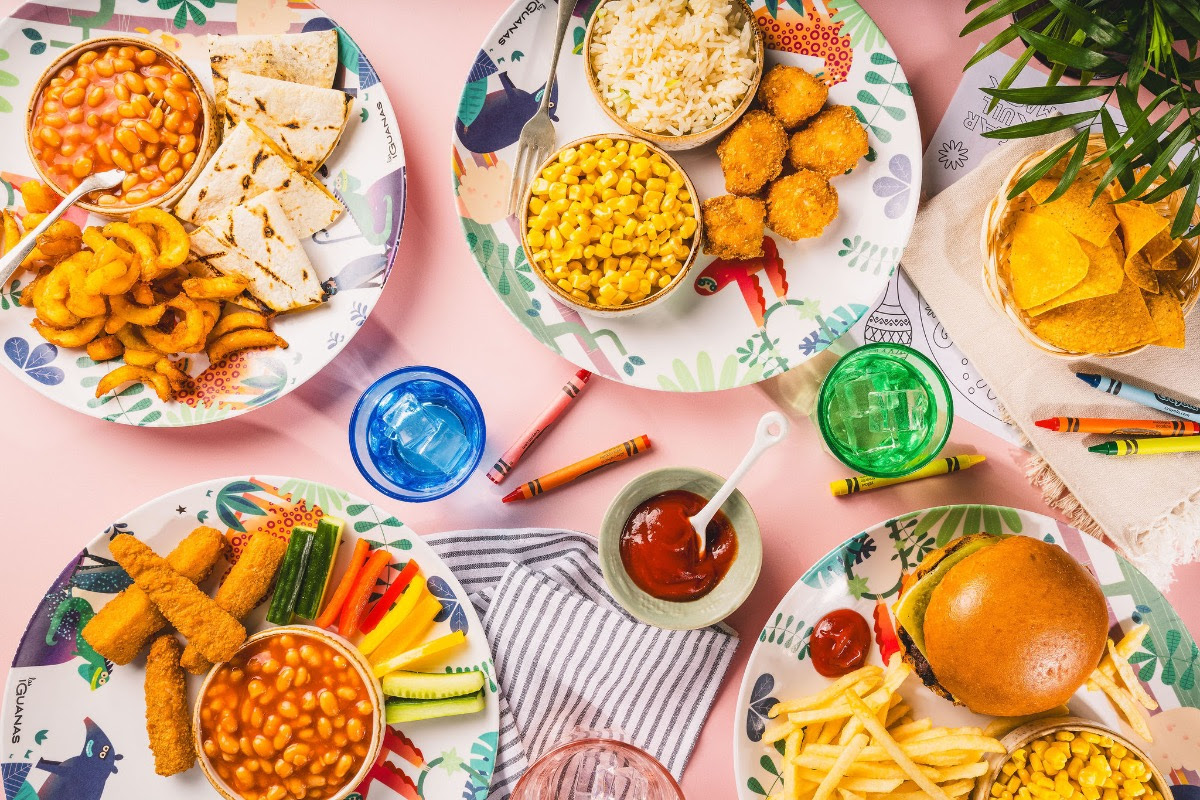 Colorful plates with various foods on a pink table
