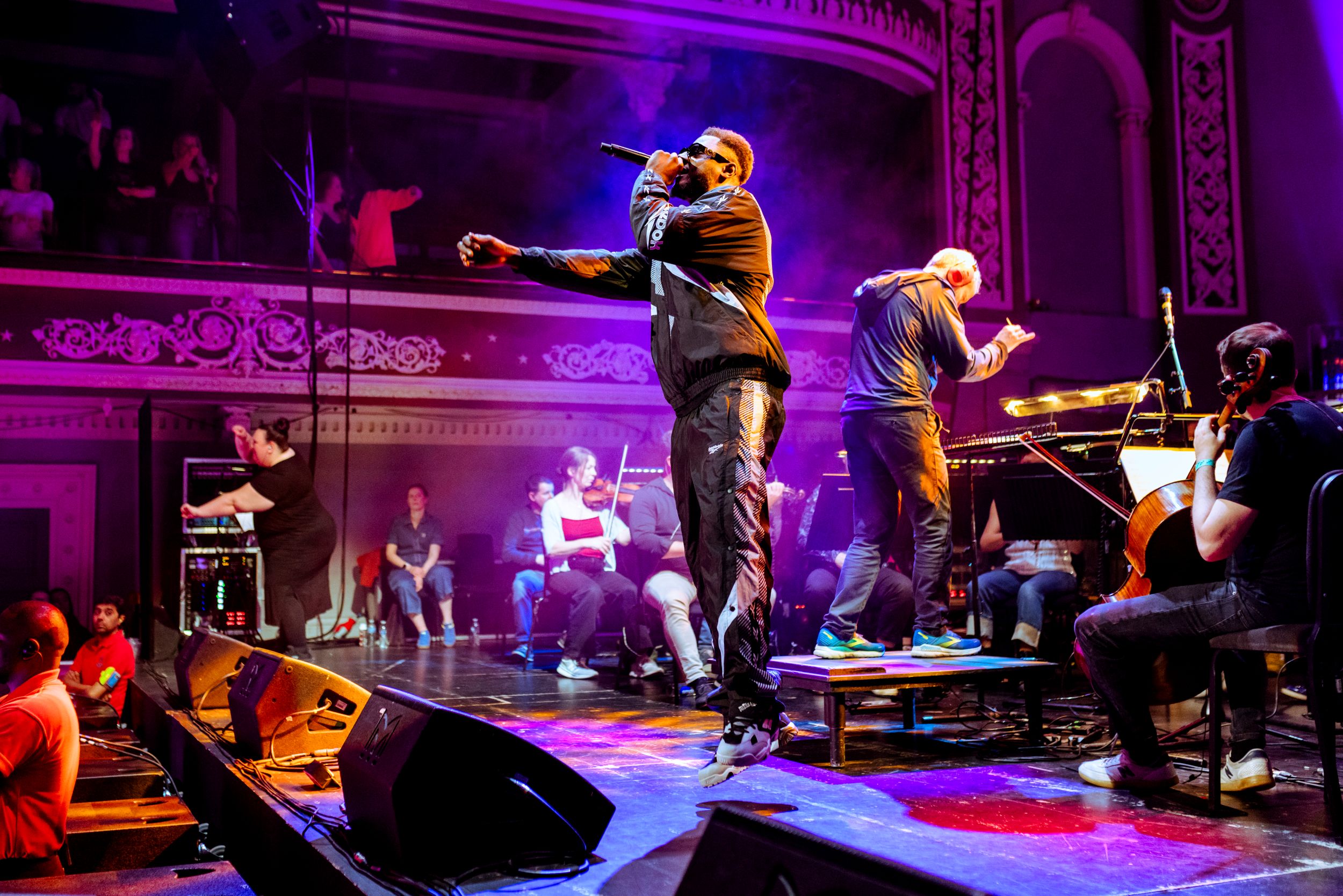Live music performance at ornate theatre with vibrant lighting