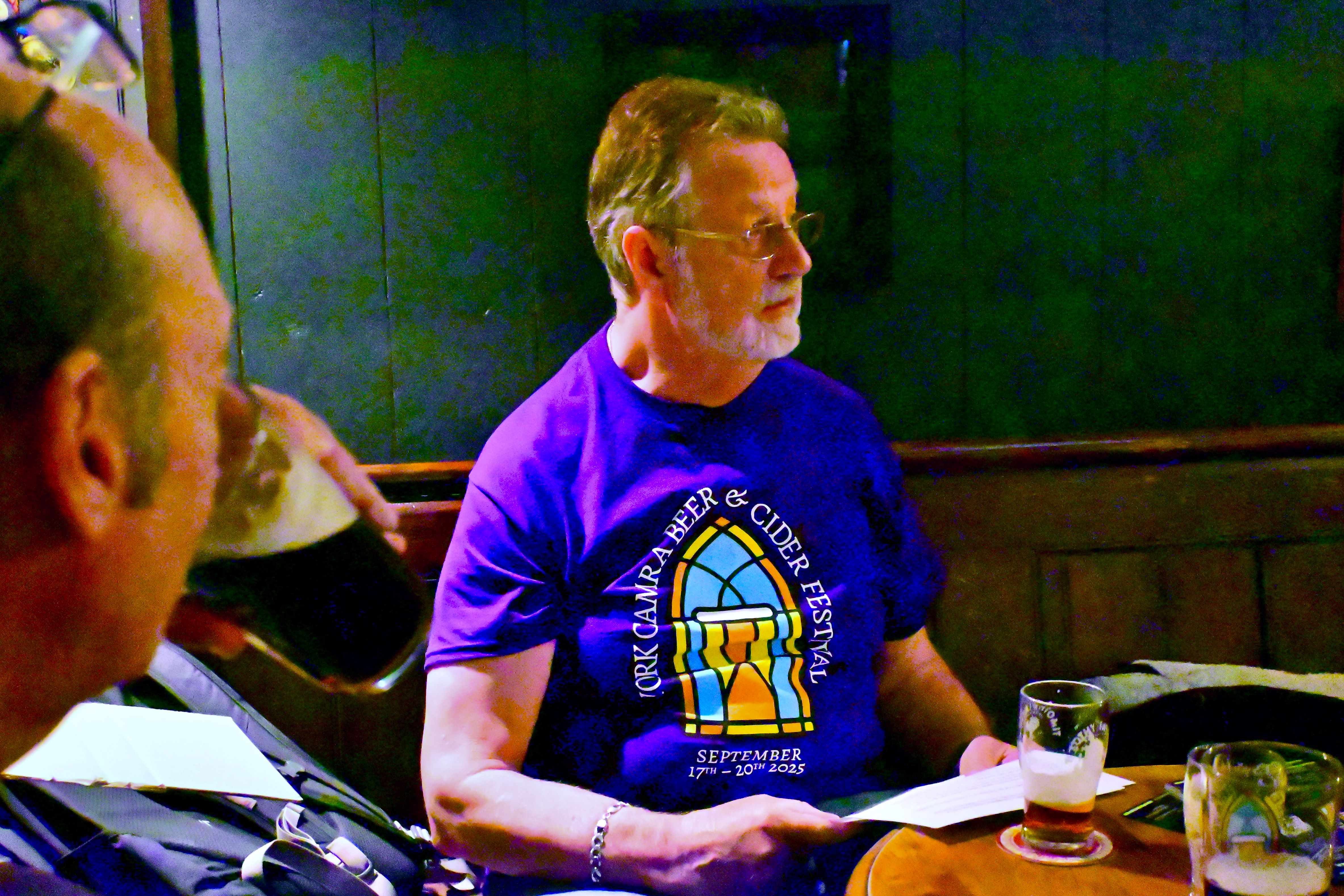 Man wearing festival t-shirt sitting in a cozy pub