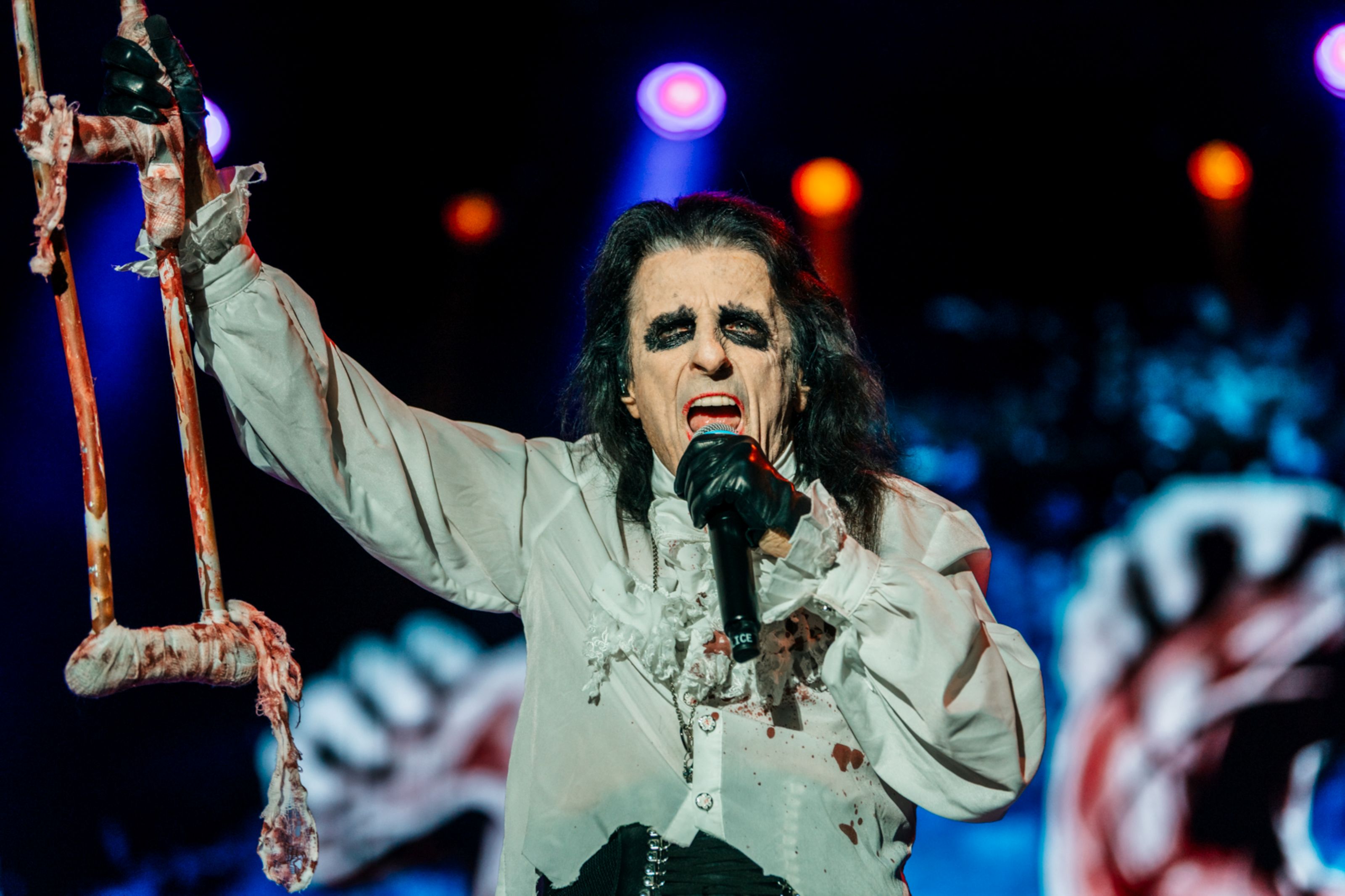 Performer in theatrical costume with bloody crutch on stage