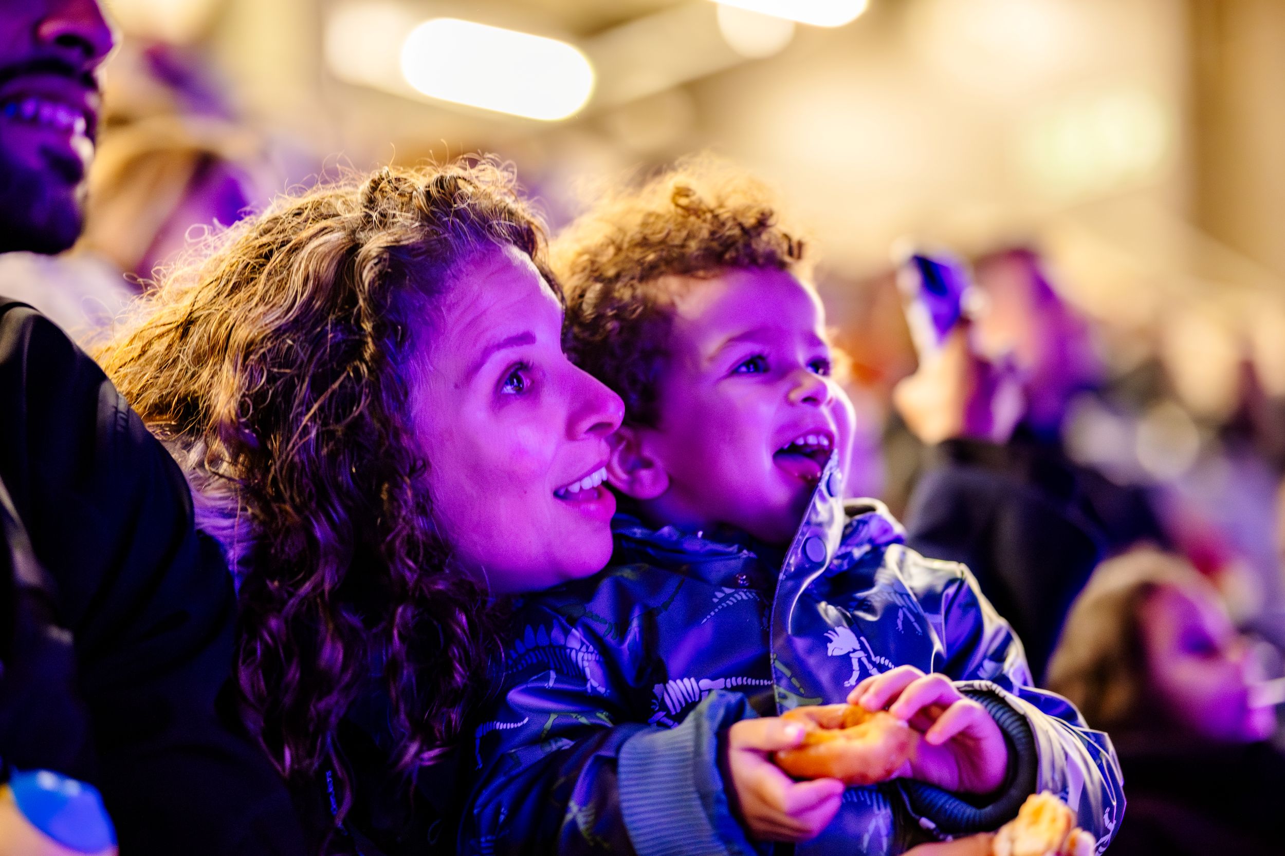 Mother and child enjoying a night event with colourful lights