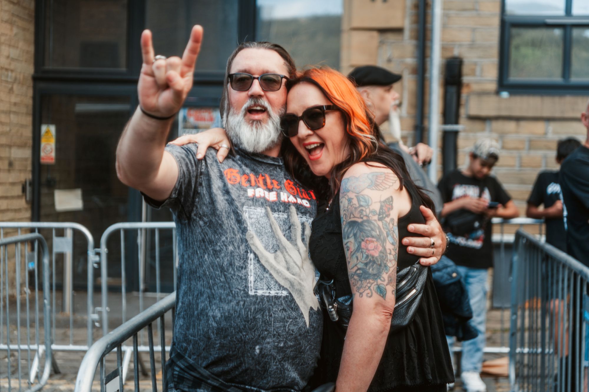 Smiling couple at outdoor music festival with brick building