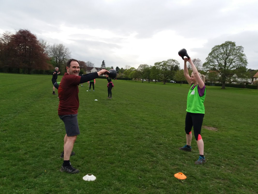 Participants engaged in outdoor fitness training at Army Fit Addingham Bootcamp, with kettlebells and cones on the grass.