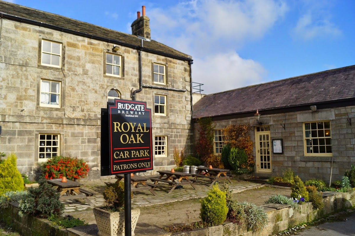 Royal Oak Inn with stone exterior, outdoor seating, and a sign indicating the car park for patrons only.