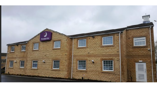 Premier Inn building with a stone facade and multiple windows, set against a cloudy sky in Gargrave, Yorkshire.