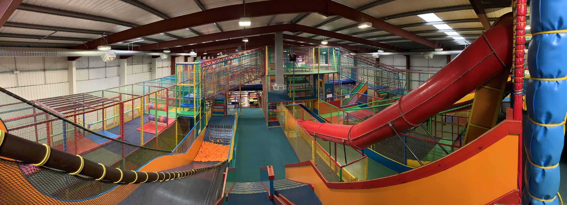 Colorful indoor play area with climbing structures, slides, and netted enclosures for children at Big Top - Hull.