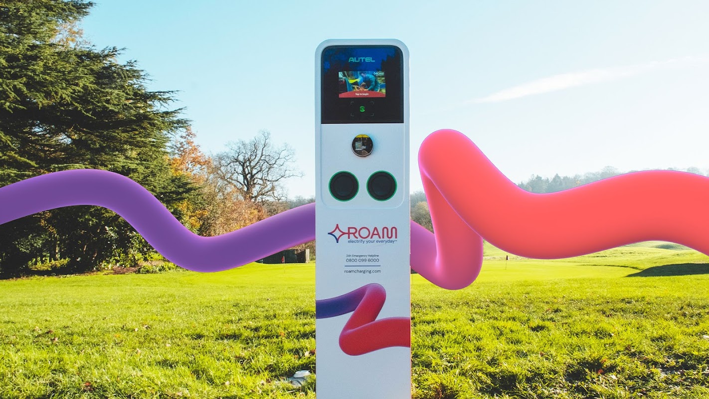 Charging station with a digital display, set in a green landscape with colorful abstract shapes around it.