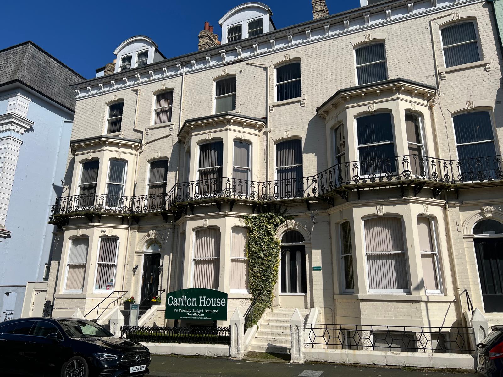 Victorian-style guesthouse with ornate balconies and large bay windows