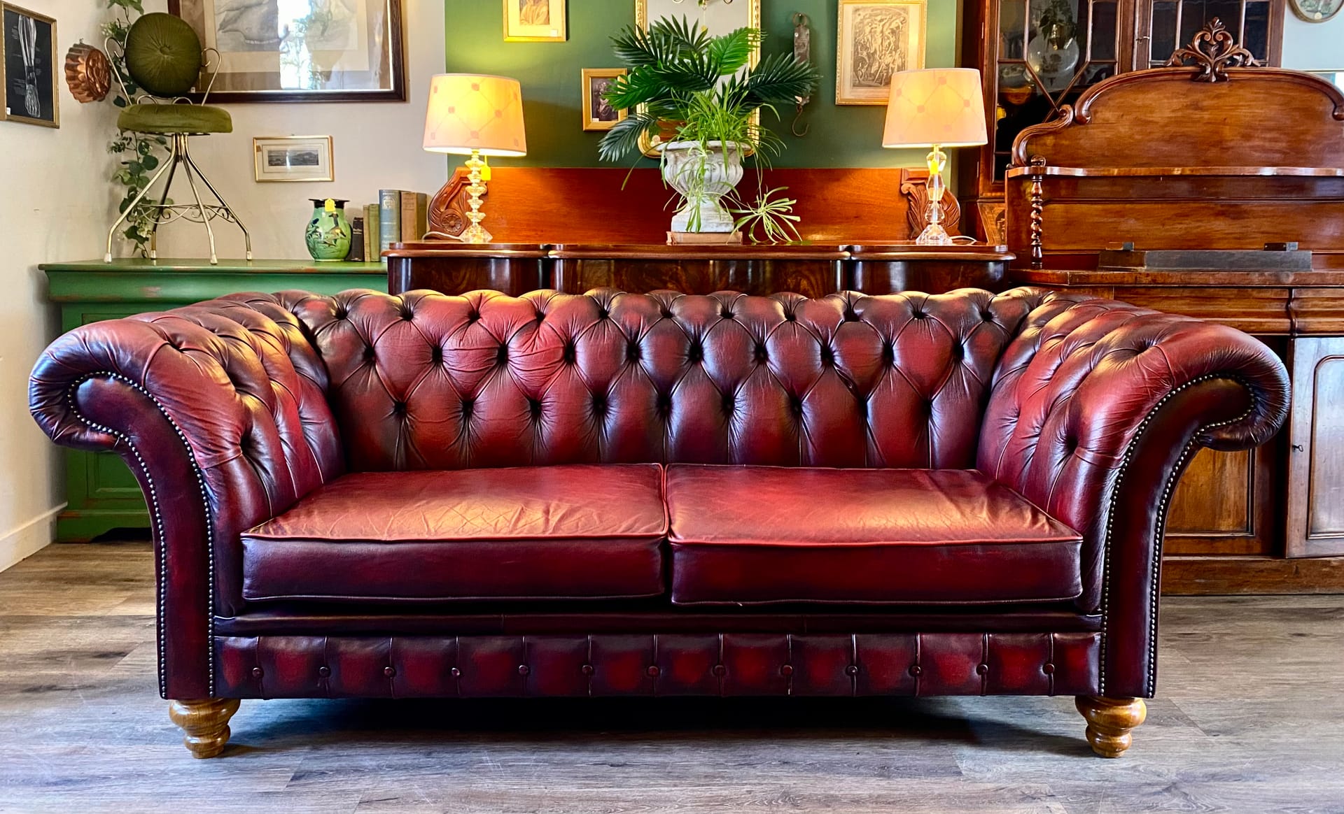 Vintage Chesterfield sofa in an eclectic antique shop with warm lighting