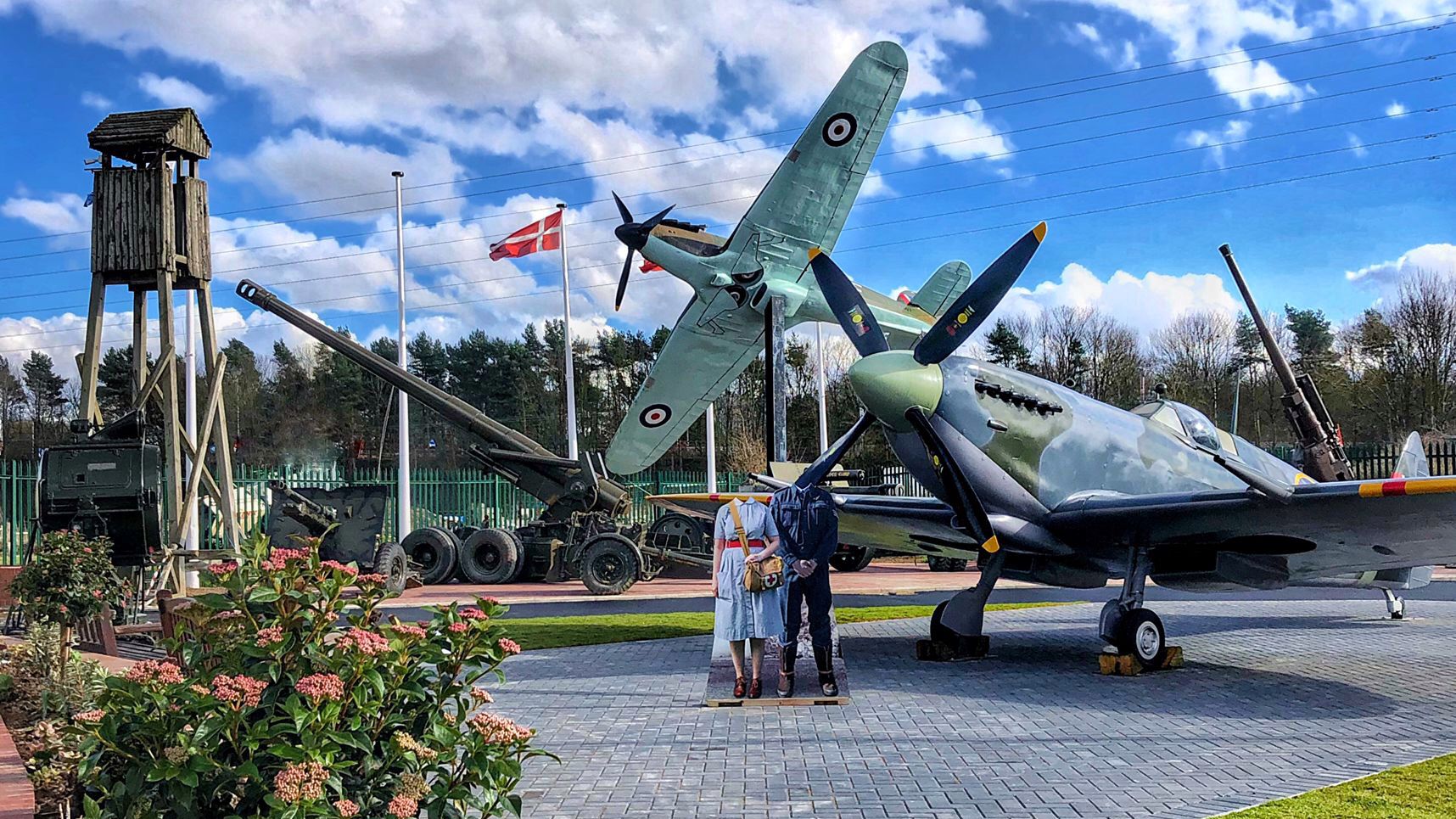 Outdoor exhibit with vintage fighter planes and military artifacts