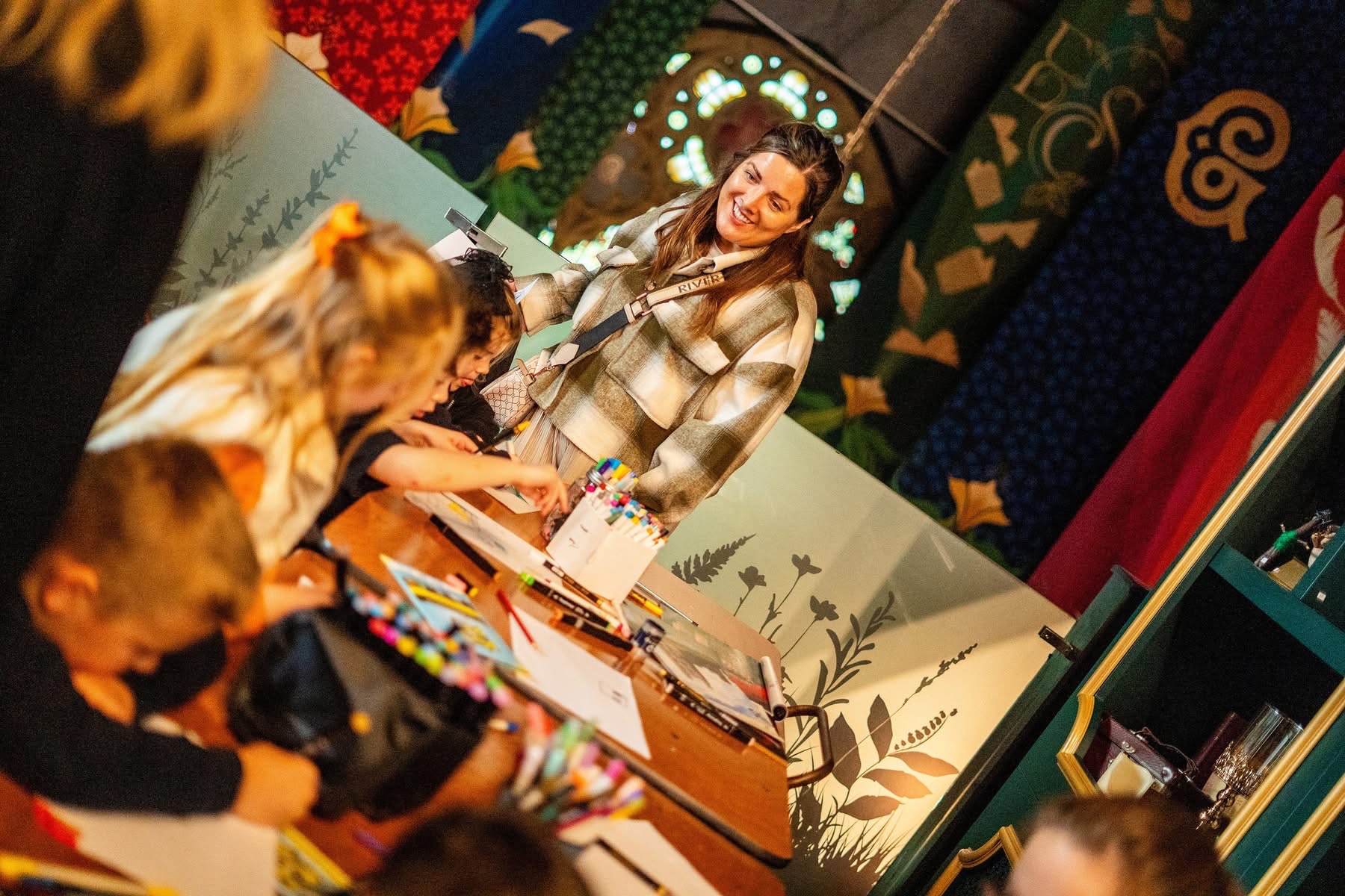 Children engaged in creative activities at a colorful, whimsical workshop space