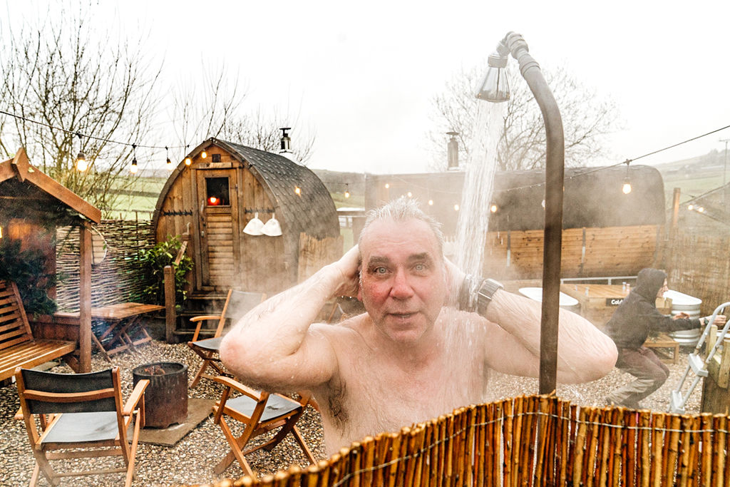 Man in outdoor shower at iglu sauna, Hebden Bridge