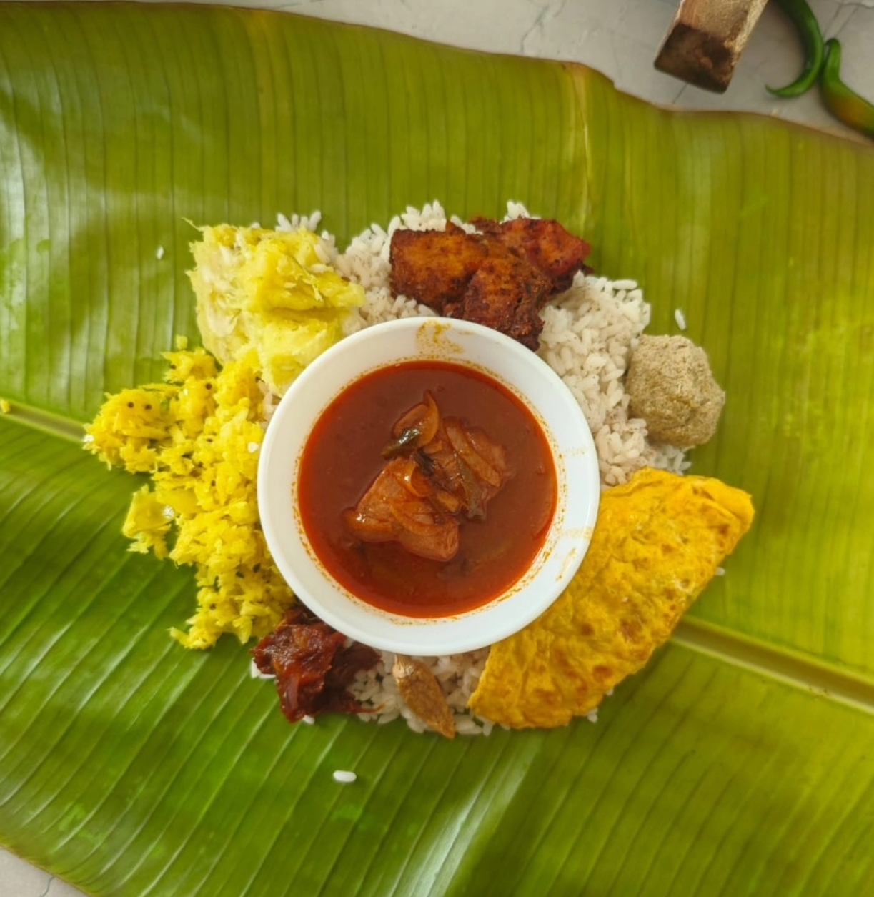 Traditional South Indian meal served on a banana leaf with rice, curry, and sides
